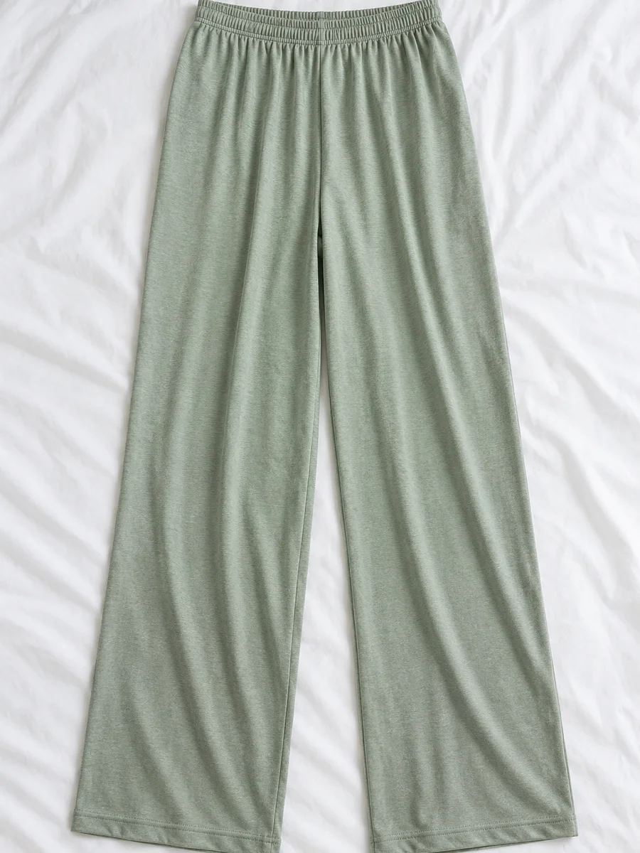 Pantalón de casa de punto, verde salvia, extendido sobre sábana blanca